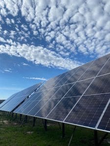 Paneles solares instalados en campo abierto bajo cielo azul, sistema fotovoltaico para autogeneración de energía.